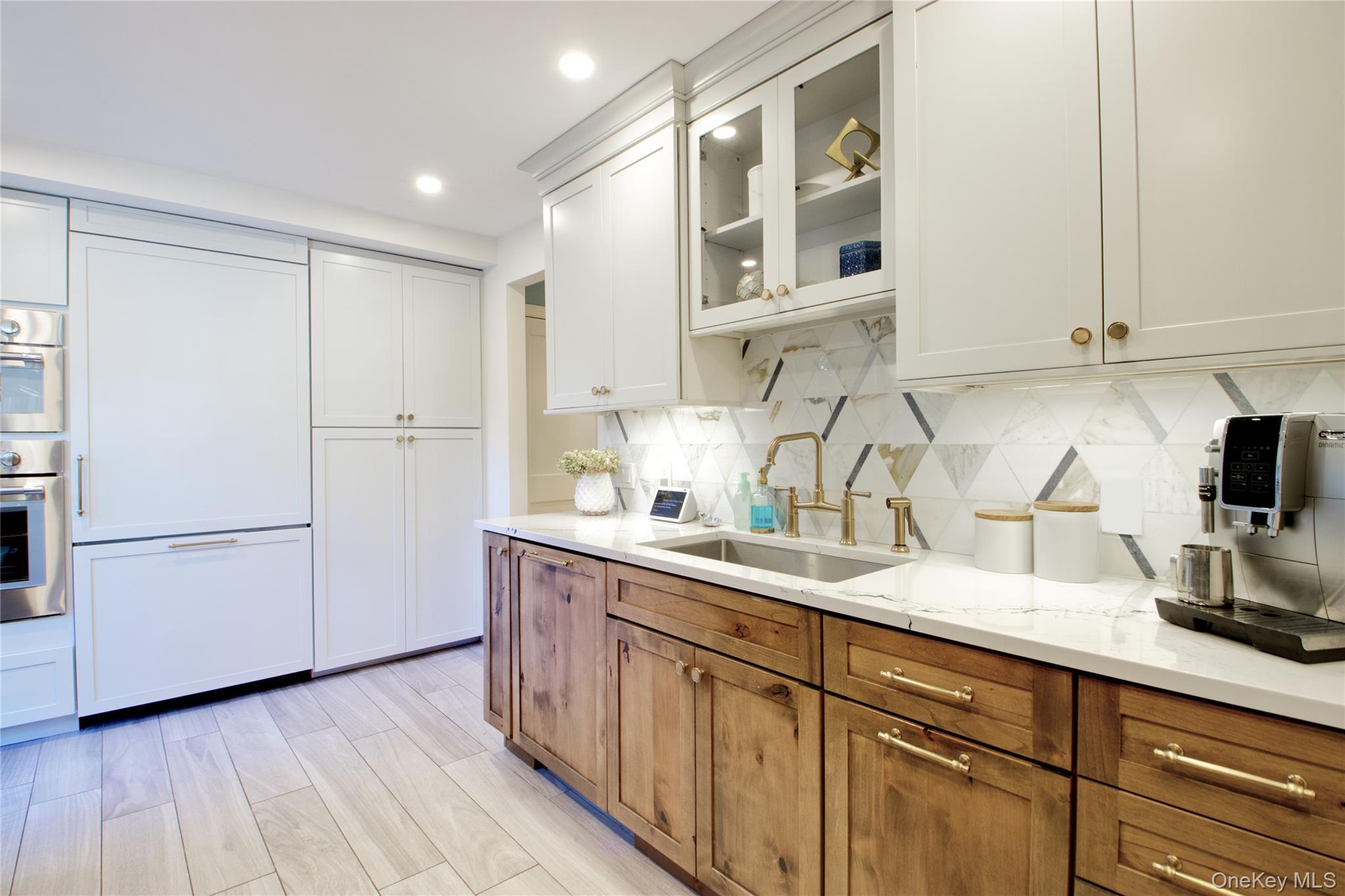112 Bromleigh Road Garden City, NY 11530 - Photo 21 of 39 a kitchen with a sink a refrigerator and cabinets
