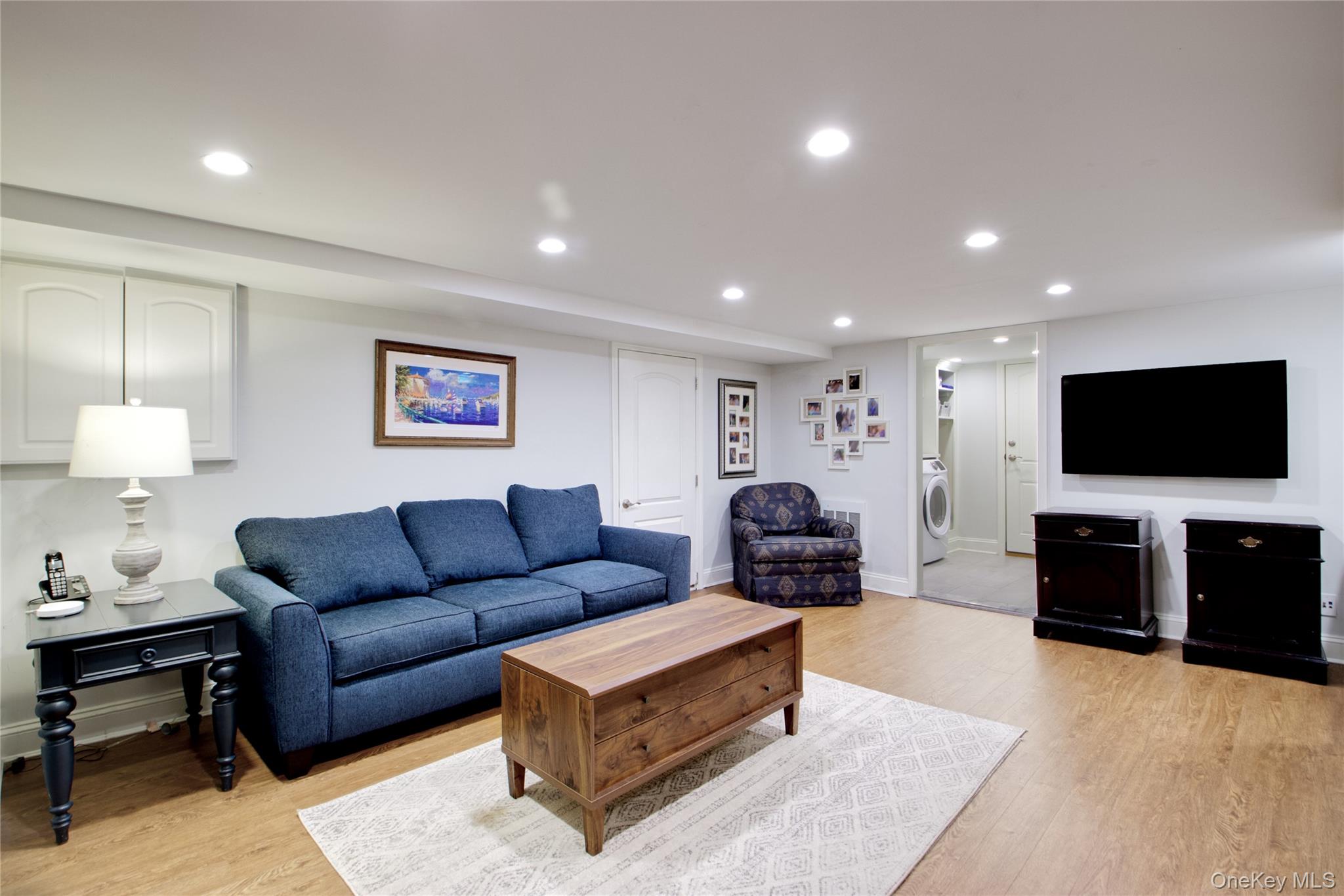 112 Bromleigh Road Garden City, NY 11530 - Photo 23 of 39 a living room with furniture and a flat screen tv