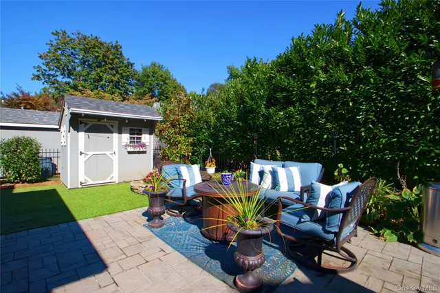 a view of a patio with table and chairs under an umbrella