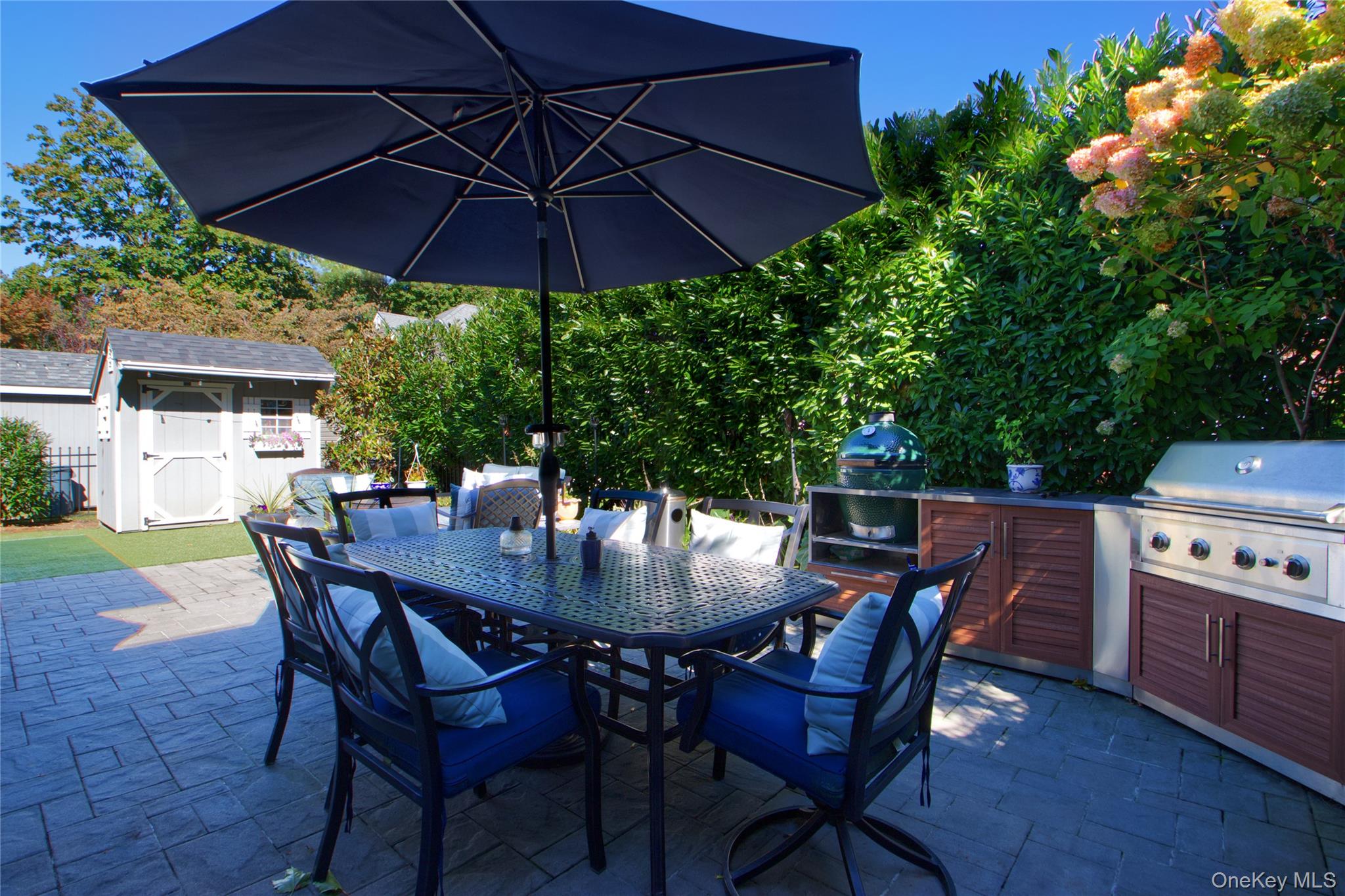 112 Bromleigh Road Garden City, NY 11530 - Photo 37 of 39 a view of a patio with table and chairs under an umbrella