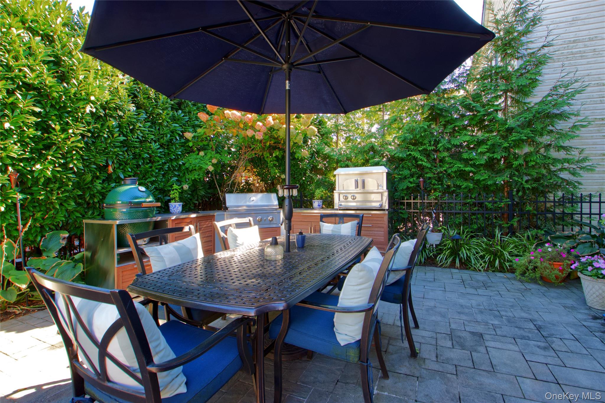 112 Bromleigh Road Garden City, NY 11530 - Photo 38 of 39 a view of a patio with table and chairs under an umbrella