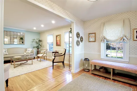 a living room with furniture wooden floor and a large window