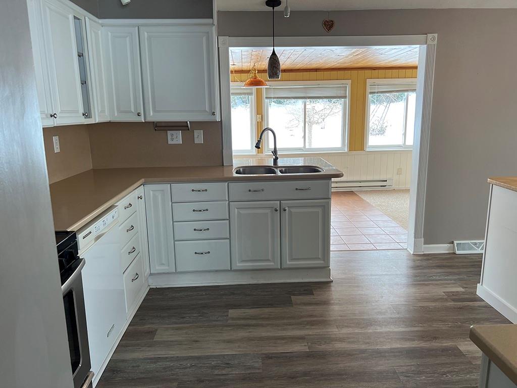 175 Jody Drive Penn Run, PA 15765 - Photo 6 of 27 a kitchen with granite countertop a stove a sink and white cabinets with wooden floor