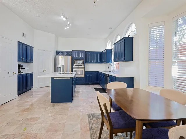 a large kitchen with dining table and chairs