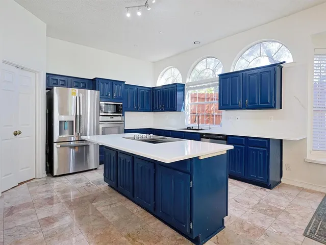 a kitchen with stainless steel appliances granite countertop wooden cabinets a stove a sink and a oven