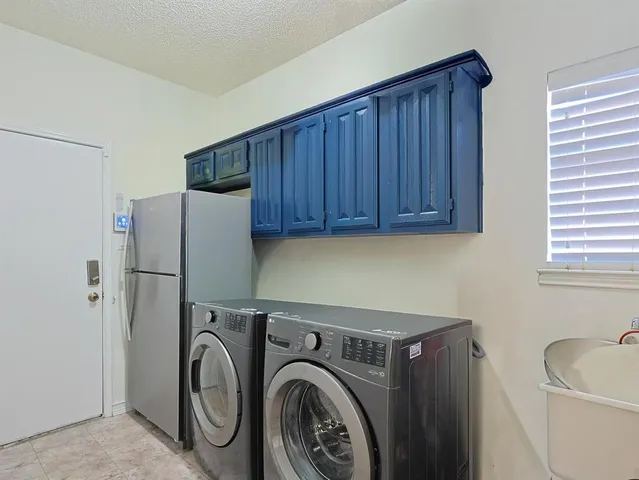 a kitchen with a stove a sink dishwasher and a refrigerator with wooden cabinets