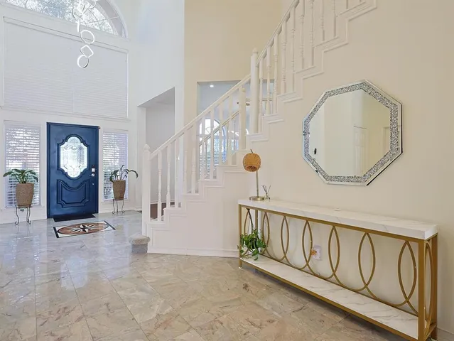 a view of a hallway with wooden floor windows and a chandelier