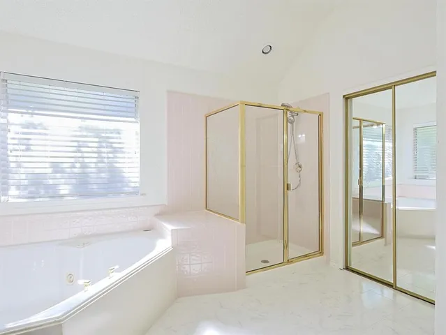 a bathroom with a tub sink and mirror