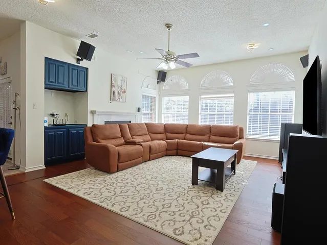 a living room with furniture a flat screen tv and a table