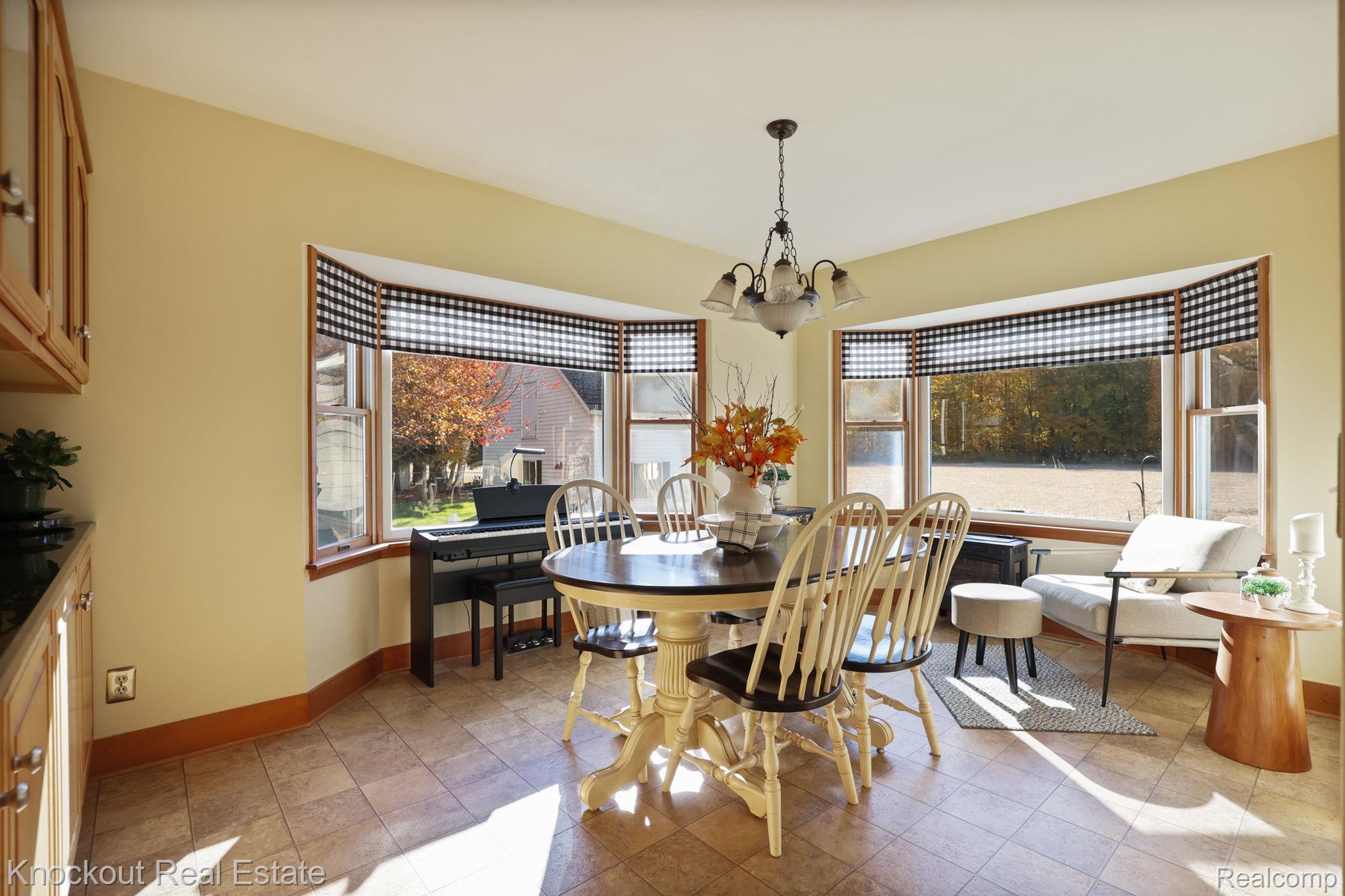 8980 Curtis Road Frankenmuth, MI 48734 - Photo 20 of 56 Dining space with healthy amount of natural light, a chandelier, and light tile patterned floors
