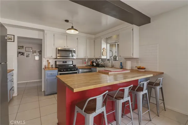 a kitchen with stainless steel appliances granite countertop a sink a stove a refrigerator and island