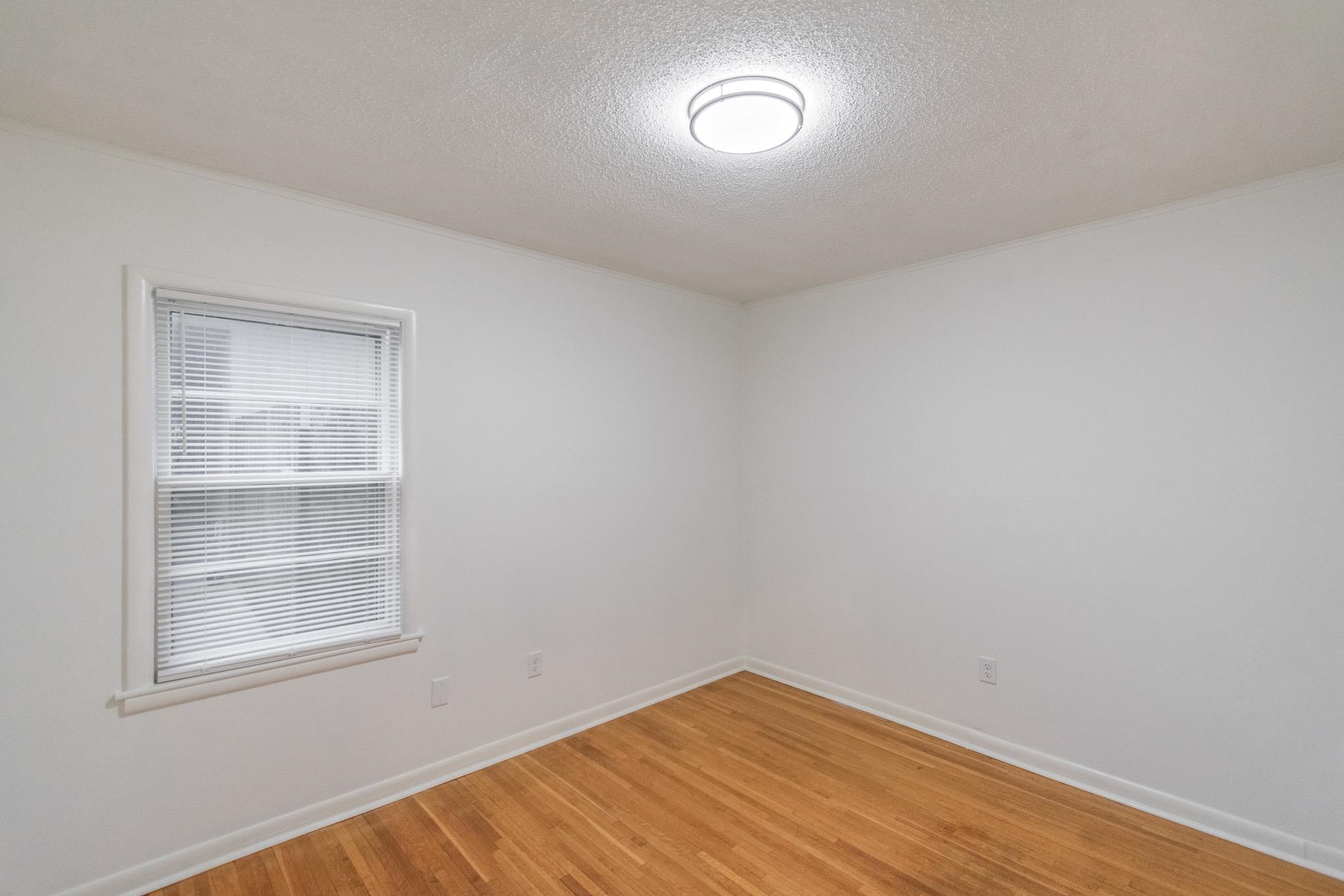 1378 Woodston Road Memphis, TN 38117 - Photo 11 of 19 a view of an empty room with wooden floor and a window