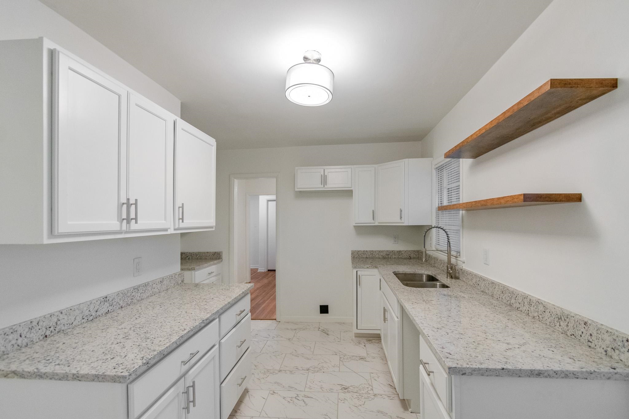 1378 Woodston Road Memphis, TN 38117 - Photo 5 of 19 a kitchen with granite countertop a sink a stove and cabinets
