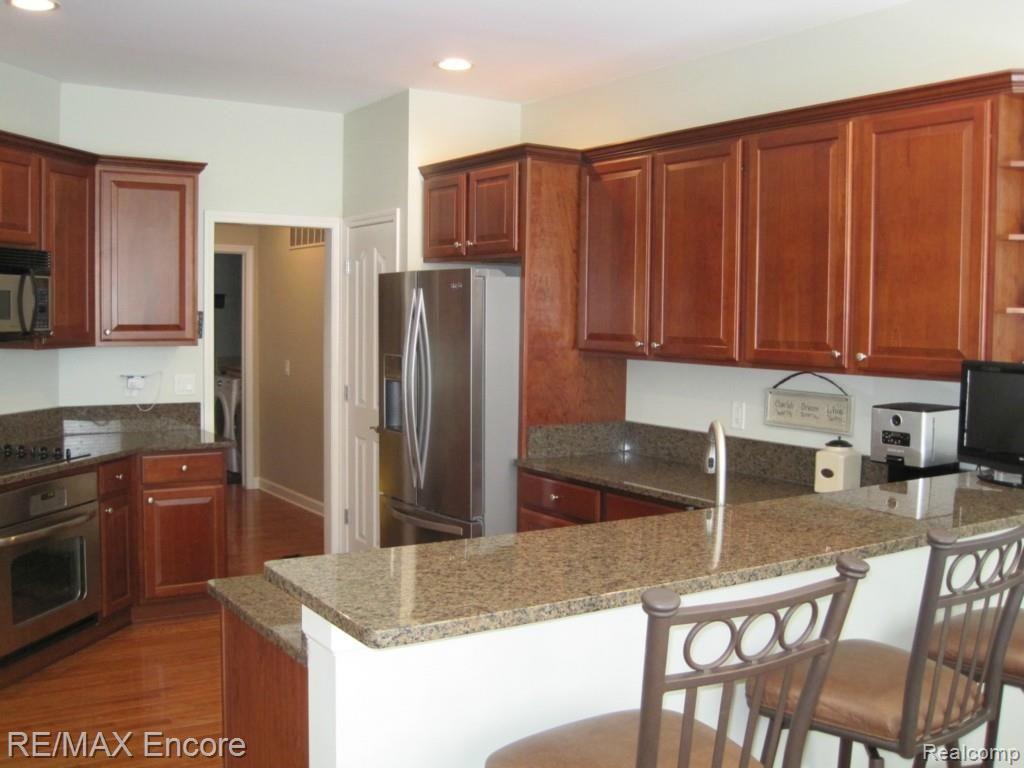 3687 Tremonte Circle, Unit 73 Rochester, MI 48306 - Photo 10 of 43 Cherry cabinets and granite breakfast bar