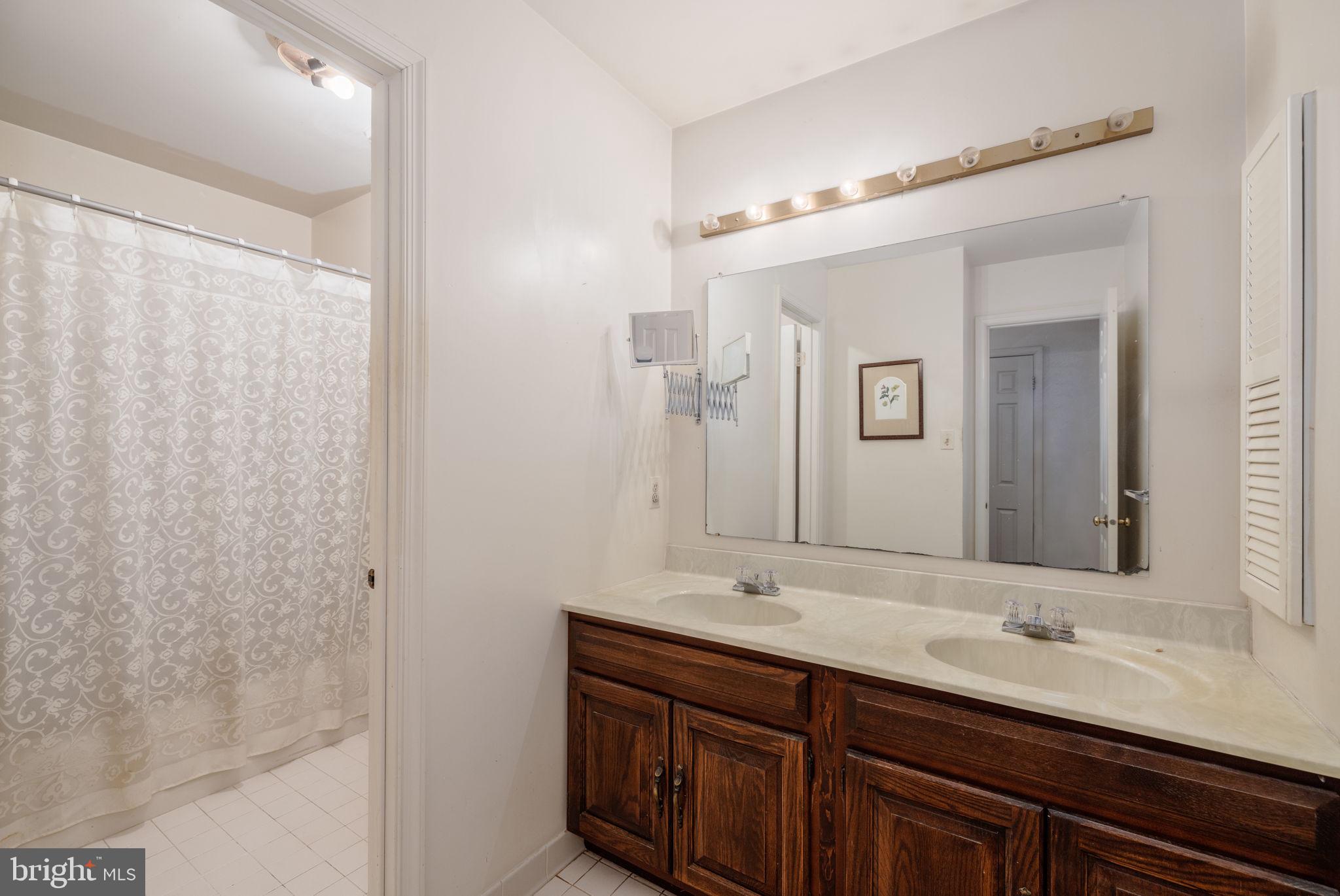 8009 Hackamore Drive Potomac, MD 20854 - Photo 12 of 19 Primary bathroom with dual vanities and shower/tub