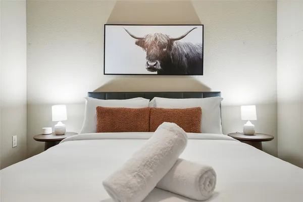 a bedroom with a bed and painting on the wall