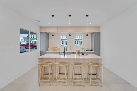 a kitchen with kitchen island granite countertop a table and chairs in it