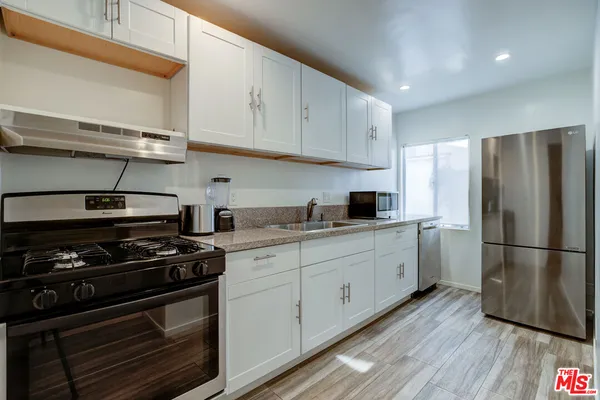 a kitchen with stainless steel appliances white cabinets and a stove top oven