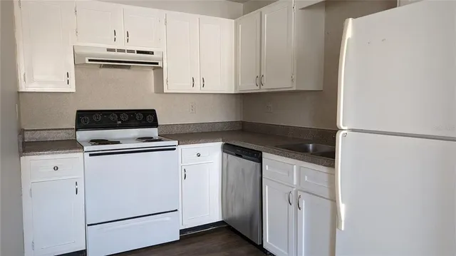 a kitchen with white cabinets and white appliances