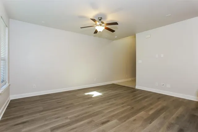 a view of a room with wooden floor and ceiling fan