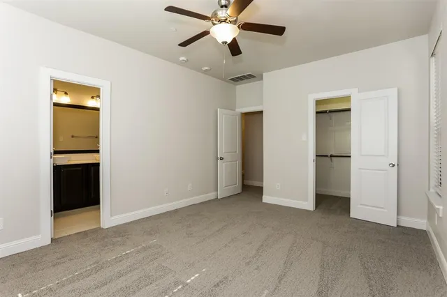 a view of empty room with window and ceiling fan