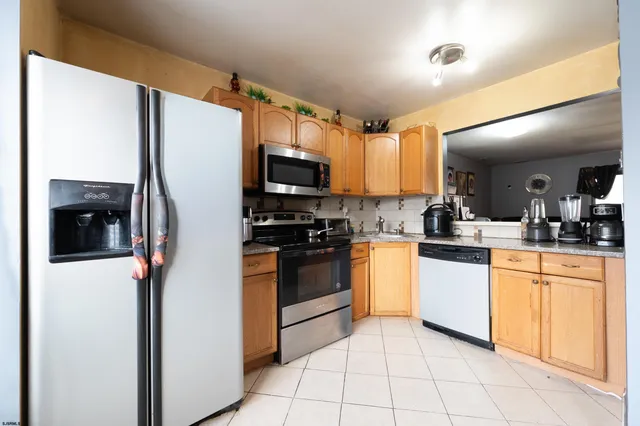 a kitchen with stainless steel appliances a refrigerator sink and microwave