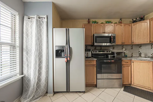 a kitchen with stainless steel appliances a refrigerator sink and microwave