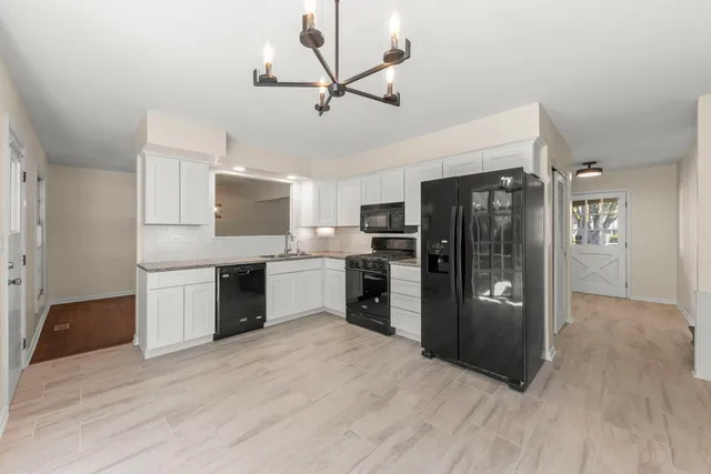 a kitchen with stainless steel appliances granite countertop a refrigerator and a sink