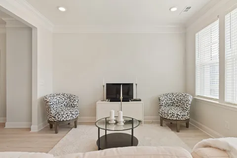 a kitchen with a sink a refrigerator a stove top oven a kitchen island and chairs with wooden floor