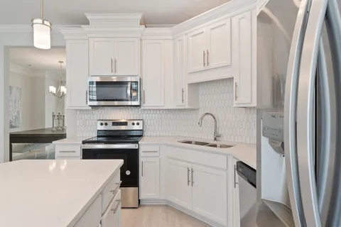 a view of a hallway with wooden floor and a living room