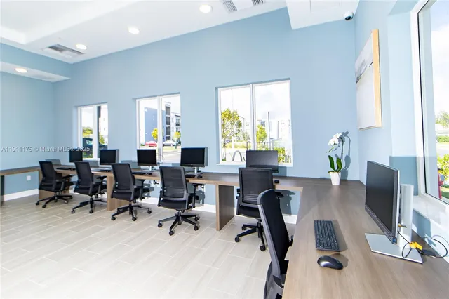 a view of a workspace with furniture and a window