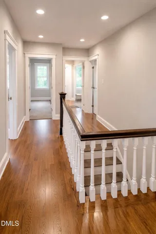 a view of a hallway with wooden floor and staircase