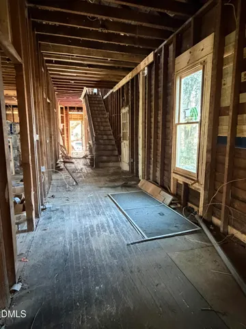 a view of an empty room with wooden floor and windows