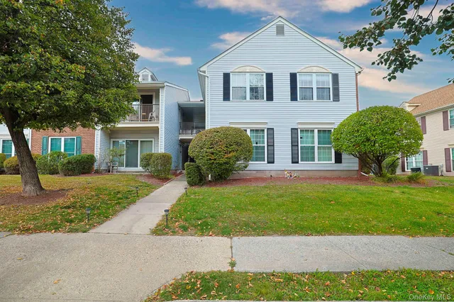 a front view of a house with a garden and plants