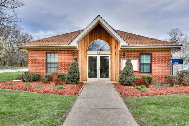 a front view of a house with a yard and potted plants