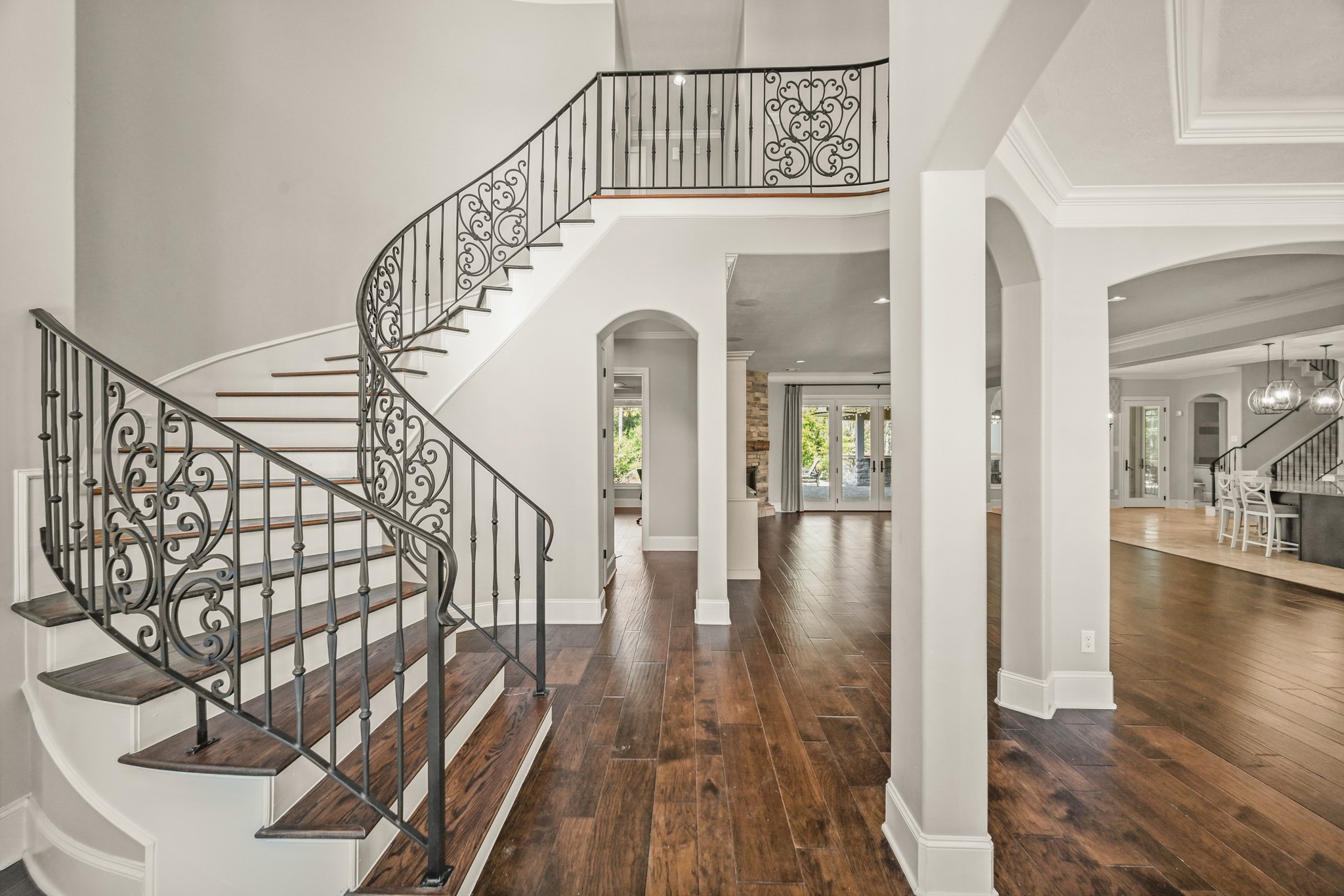 27322 Silver Jade Court Spring, TX 77386 - Photo 5 of 45 Entry features a wrought-iron staircase, wood flooring, and a high ceiling, creating a grand and inviting first impression.