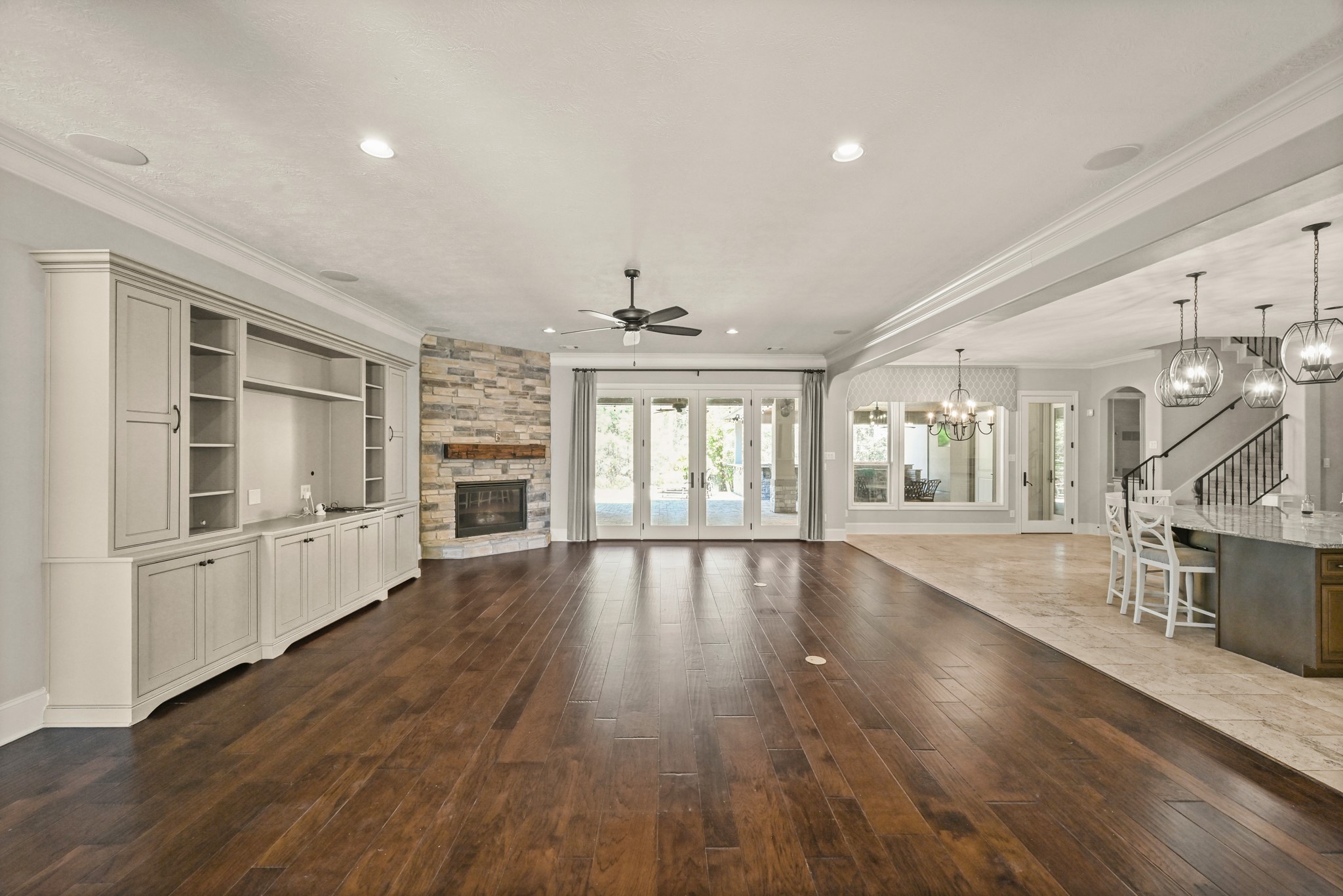 27322 Silver Jade Court Spring, TX 77386 - Photo 9 of 45 Family room features dark wood floors, a stone gas-log fireplace, custom built-ins, and double doors that open to the outdoor oasis.