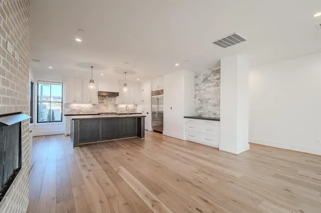 a large kitchen with a lot of white cabinets and stainless steel appliances