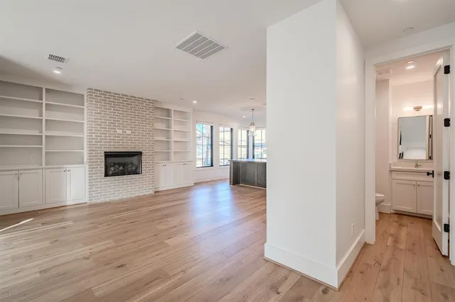 a view of a living room with wooden floor and a fireplace