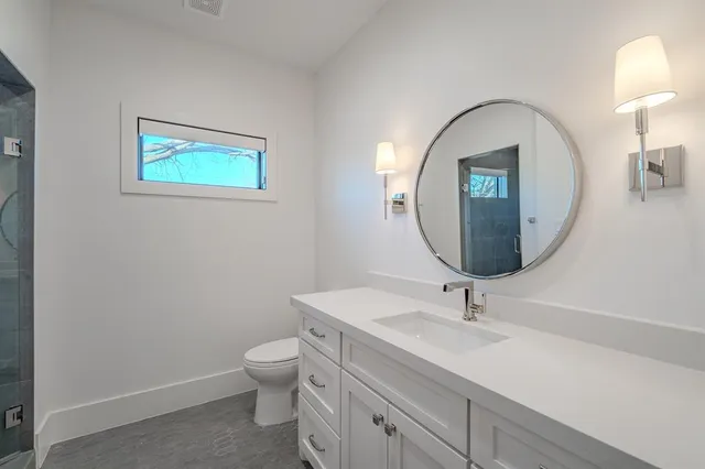 a bathroom with a toilet a sink and mirror