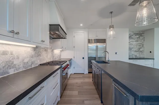 a kitchen with stainless steel appliances a sink stove and cabinets