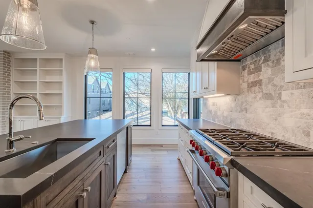 a kitchen with granite countertop a stove and a sink