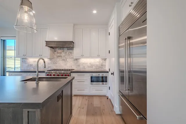 a kitchen with kitchen island a counter top space a sink stainless steel appliances and cabinets