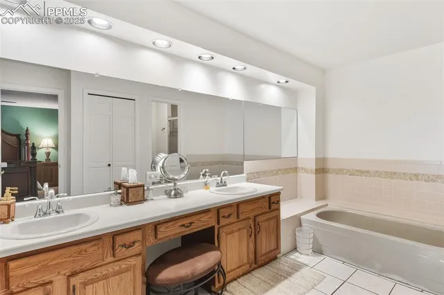 a bathroom with a tub double sink and mirror
