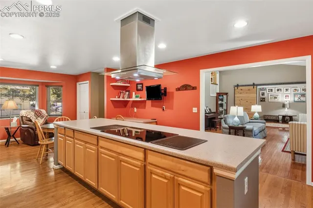 a kitchen that has a lot of cabinets a sink and wooden floor