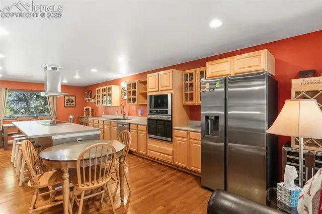 a kitchen with stainless steel appliances granite countertop a refrigerator and a stove top oven