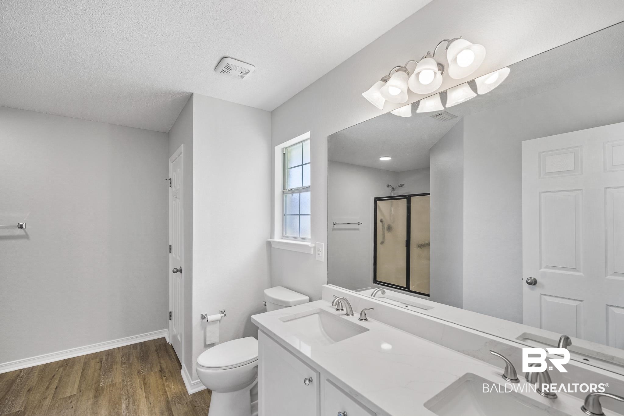 9814 Woolrich Avenue Fairhope, AL 36532 - Photo 20 of 29 Bathroom with hardwood / wood-style floors, a textured ceiling, toilet, and double sink vanity