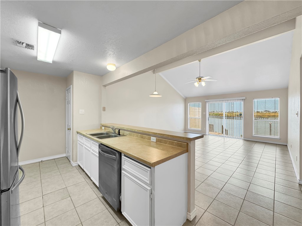 14302 Cruiser Street, Unit A Corpus Christi, TX 78418 - Photo 9 of 28 a kitchen with a stove a sink and a refrigerator