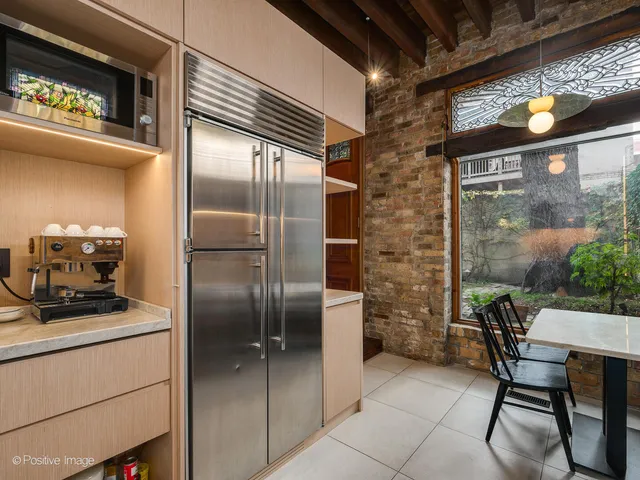 a kitchen with stainless steel appliances a refrigerator and a table