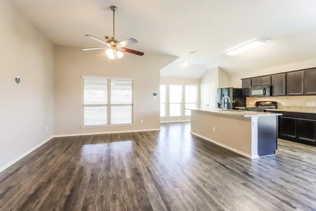 a view of kitchen with sink microwave and cabinets